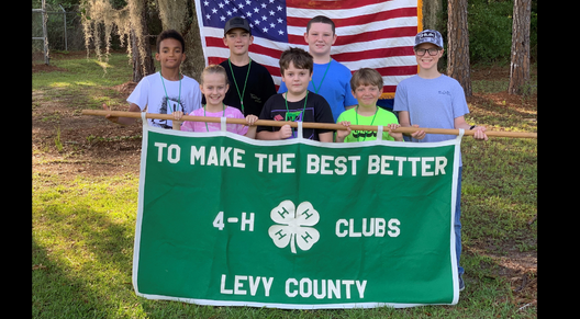4-H Members holding the county 4-H banner and American Flag