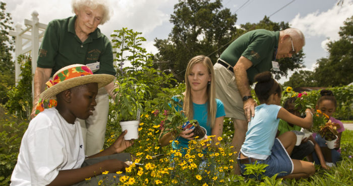 students with master gardeners in the garden