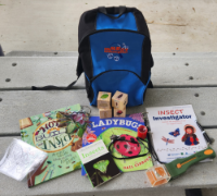 Insect Investigator backpack kit with activities and books on table