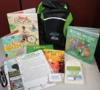 Family Green Living backpack kit with books and activities on a table