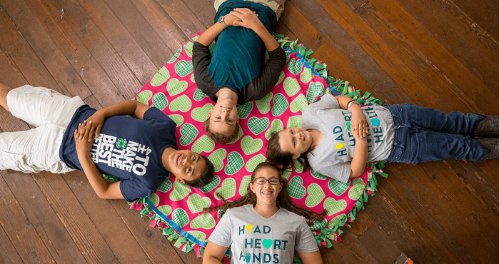 4-H members laying on 4-H blanket