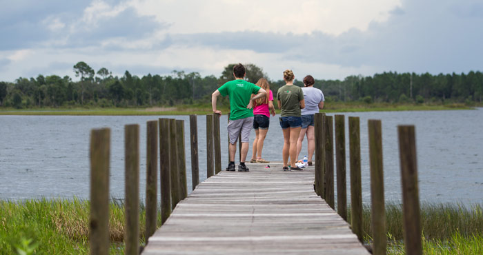 Group standing on dock by lake