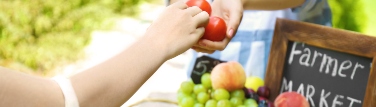 Image of someone handing someone else  tomatoes