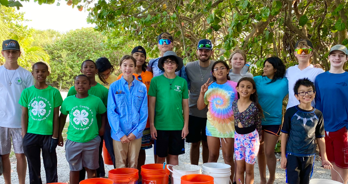Sunshine Harvester club members pose for group photo with the buckets they used for beach clean up.