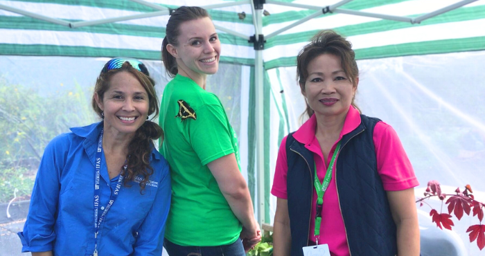 Three women volunteers posing for the camera during Art in the Garden event