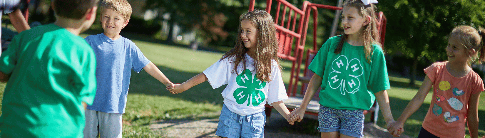 A group of children in 4-H shirts in a playground.