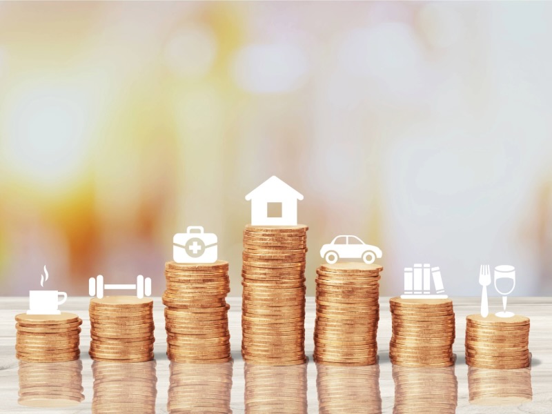 Stacks of coins of varying heights with icons for coffee, fitness, healthcare, housing, car, books, and dining.