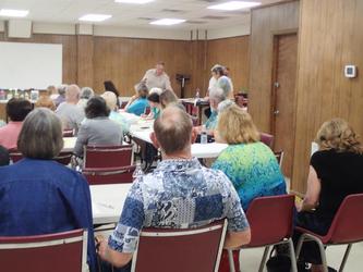 A group of individuals seated in a large room being trained to become Master Gardener Volunteers