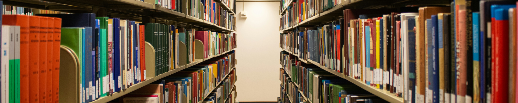 library shelves hold books upon books, in a look down an aisle. [credit: unsplash.com, zoshua colah]
