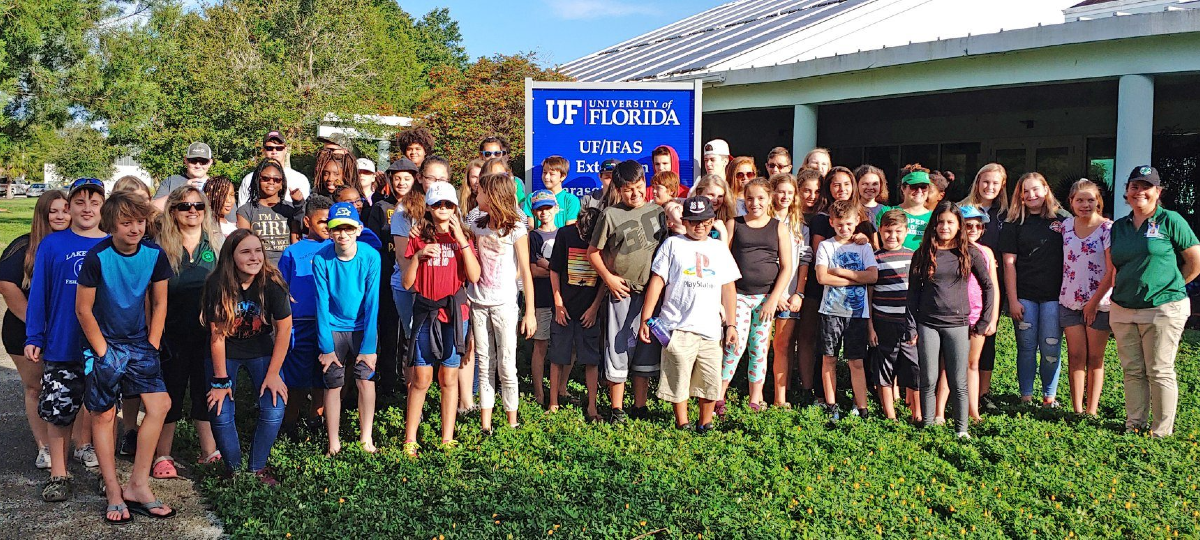 youth, staff and volunteers pause for a group photo before embarking on a summer camp trip
