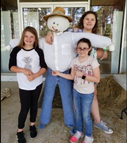 3 girls showing off their scare crow