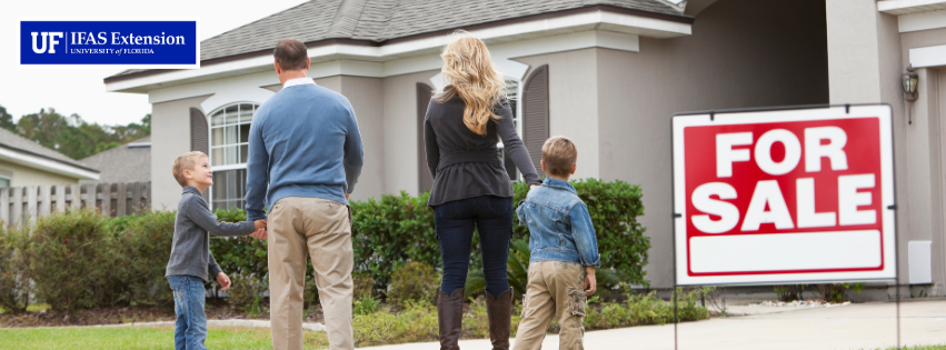 family in front of home with a for sale sign